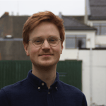 Bilde av Mathias. Smilende mann med briller.