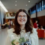 Bilde av K. Joanna Melby Myhre. Hvit kvinne med mørkt hår, som smiler mot kamera. Foto: Torstein Lund Sperstad.