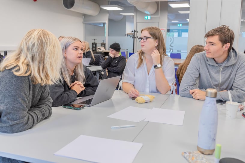 Bilde av fire tillitsvalgte som sitter rundt et bord og diskuterer med hverandre.